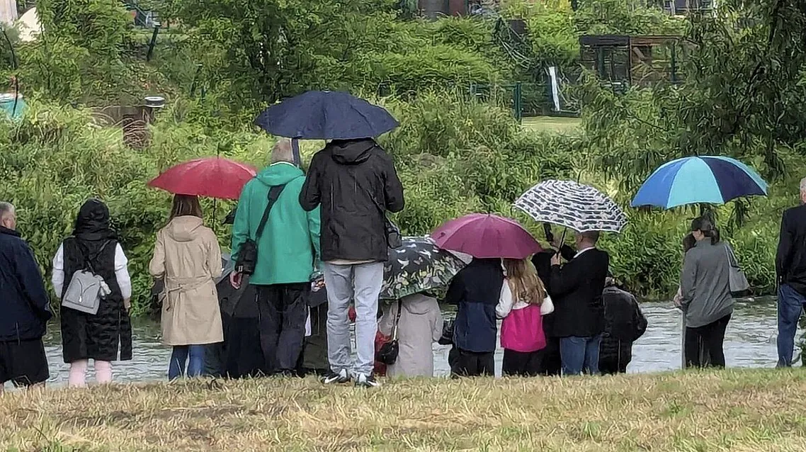 Gut beschirmt kamen die einzelnen Tauffamilien zur Taufe "ihres" Kindes zum Fluss.